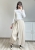 Minimalistyczne spodnie kopertowe w kolorze beżowym stylizacja basic outfit Beżowe spodnie z szeroką nogawką i zakładanym przodem styl miejski casual