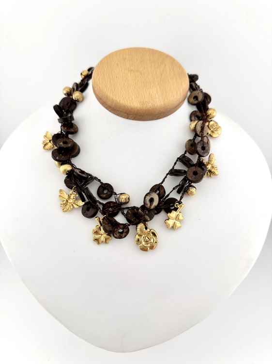 Stylowy naszyjnik damski chocker w odcieniach brązu z dodatkiem złotych zawieszek charms. Idealny do codziennych stylizacji.