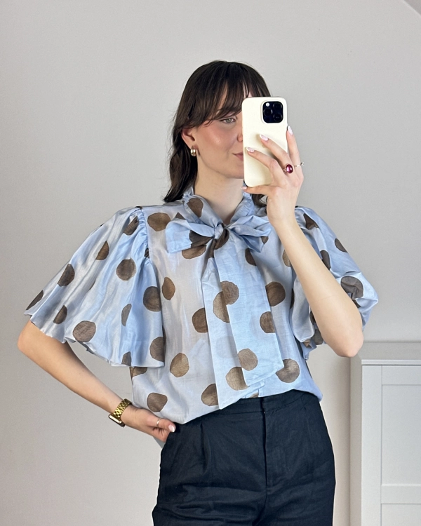 Elegancka bluzka w groszki (polka dot) błękitna – stylizacja z czarnymi spodniami.